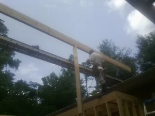 Carpenter setting a ridge beam over a new addition frame — Ice Dam Removal by Roofing Brothers in Red Bud