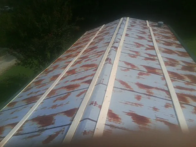 Rusted metal roof panels with new wood purlins before replacement — Storm Damage Roof Repair in Red Bud by Roofing Brothers