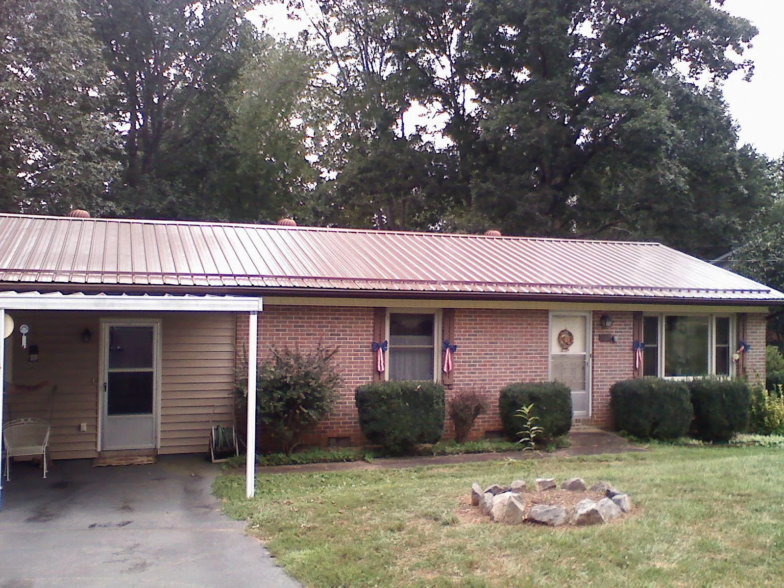 Bronze metal roof and carport on a brick ranch home — Roof Repair work by our crew in Red Bud
